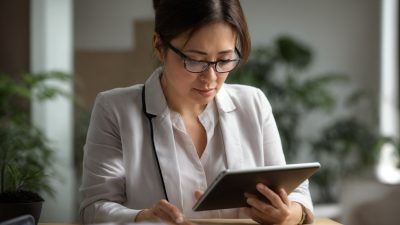 Perempuan profesional sedang meninjau data kesehatan di ruang kerjanya